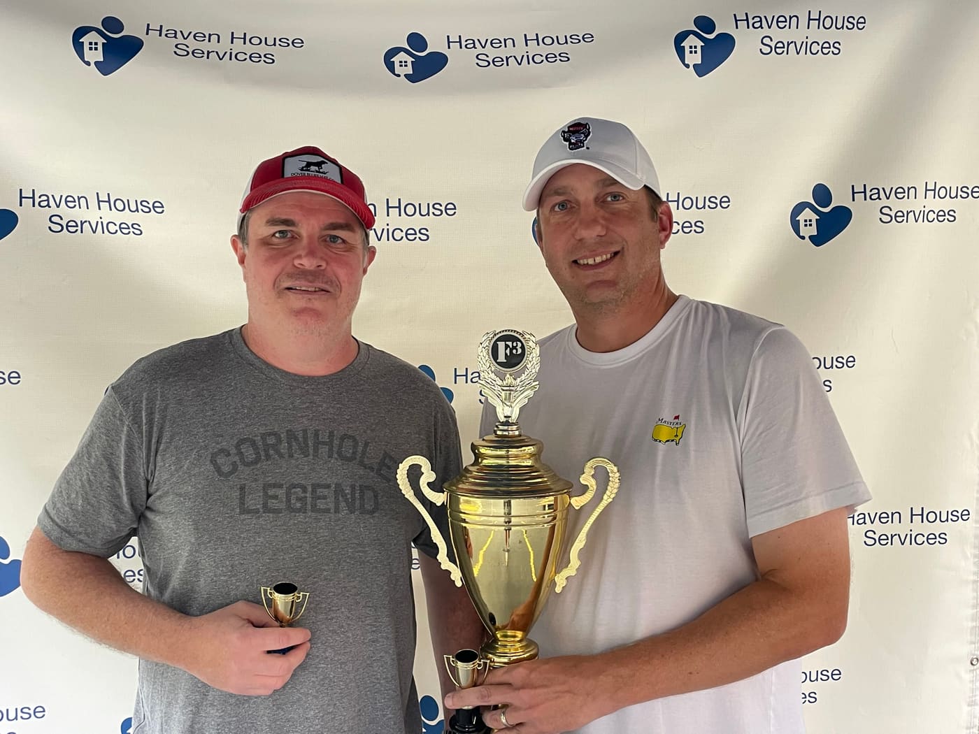 The 2025 champions holding the trophy in front of the Haven House Services backdrop